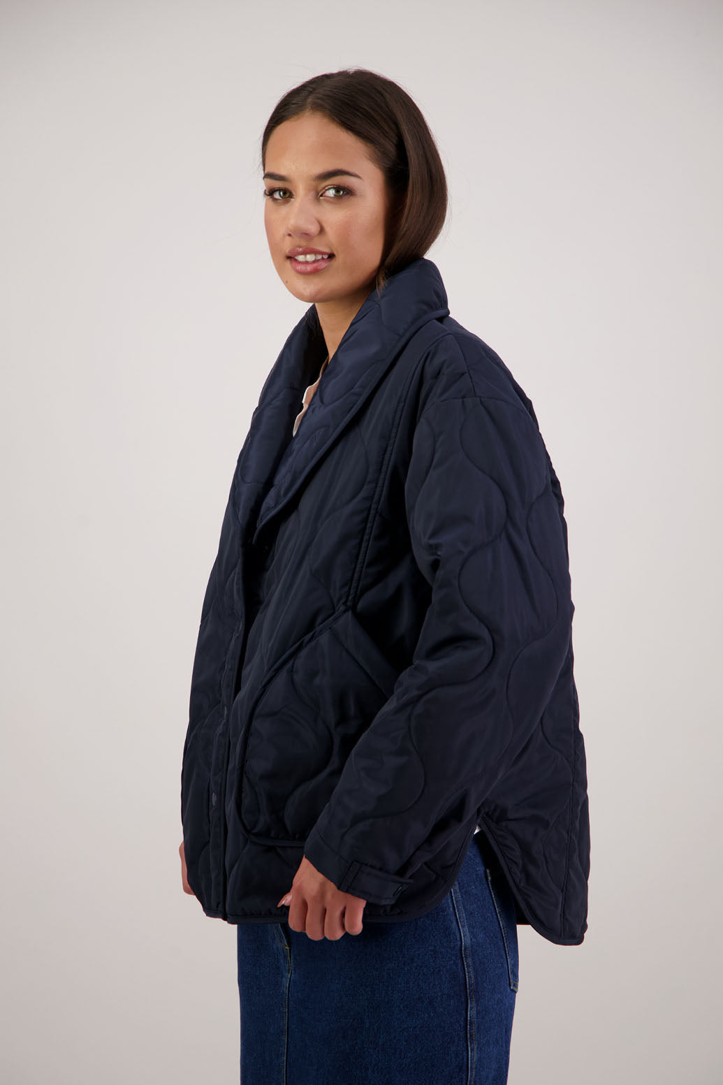 BESTSELLER. Chapman Quilted Jacket in Ink by Briarwood NZ. Quilted swirl design, high collar, side split detail, buttons front, stitched on pockets, slightly longer in the back, box fit, lined
