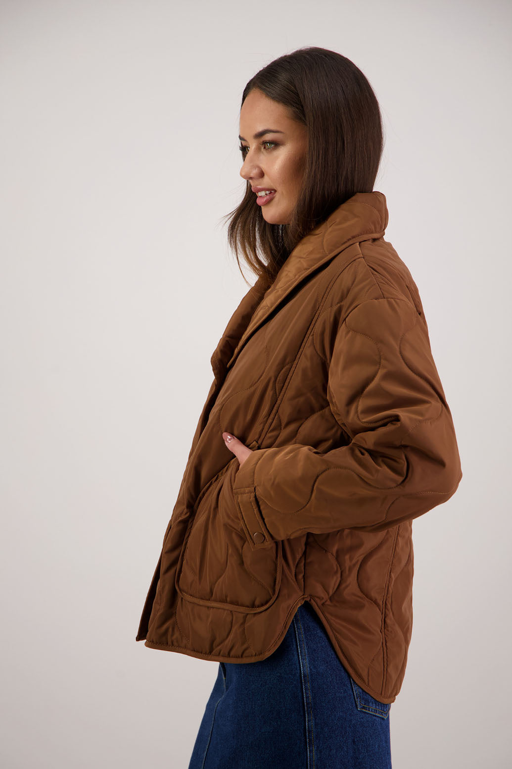 BESTSELLER. Chapman Quilted Jacket in Tan by Briarwood NZ. Quilted swirl design, high collar, side split detail, buttons front, stitched on pockets, slightly longer in the back, box fit, lined
