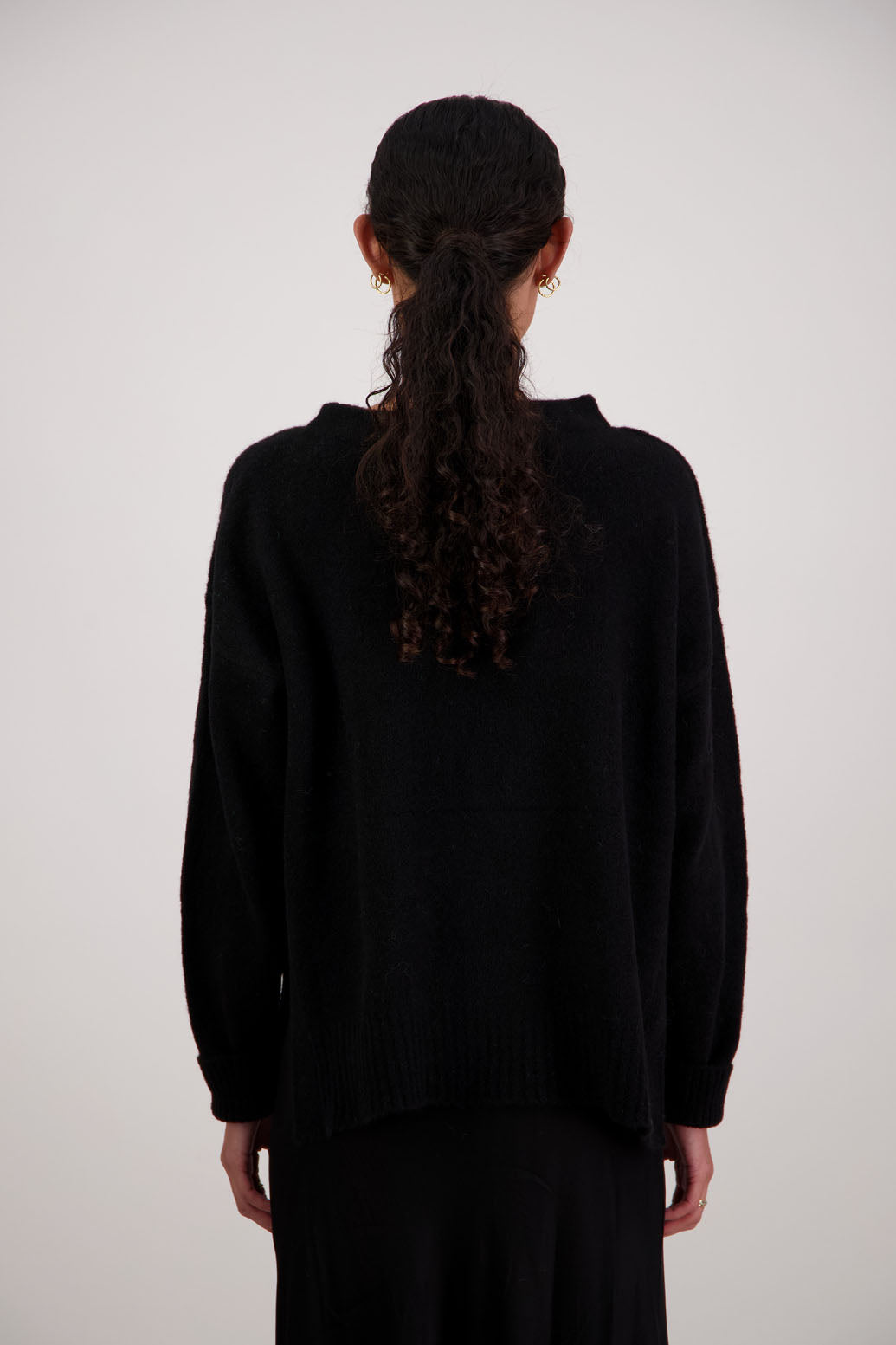 Feather Jumper in Black by Briarwood NZ. Alpaca/Wool blend long sleeve, funnel neck jumper with side splits and longer at the back
