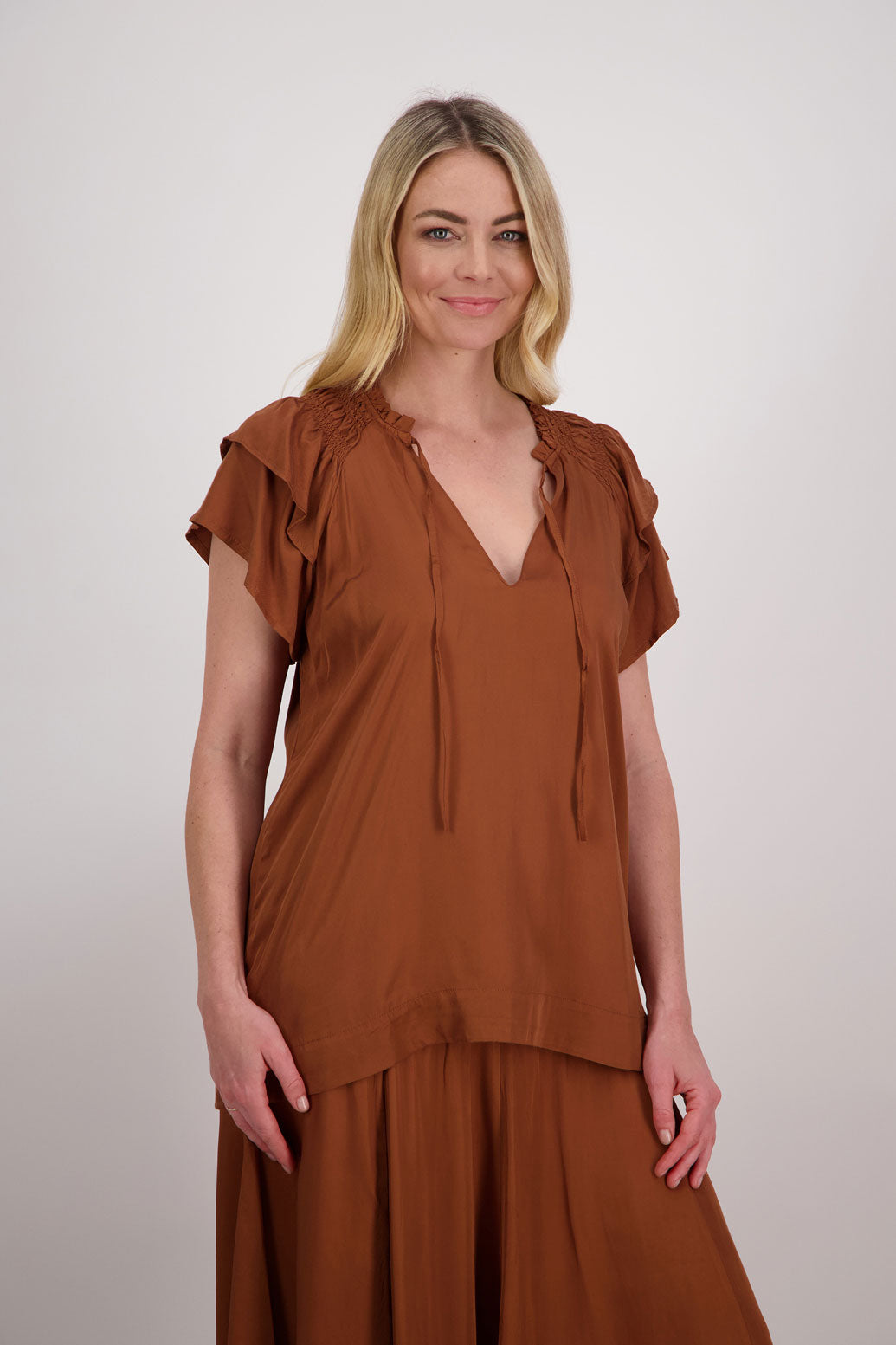 Pansy Womens Short Sleeve top with V Neck and Tie. Double ruffle over the shoulder and shaped hem. Tan