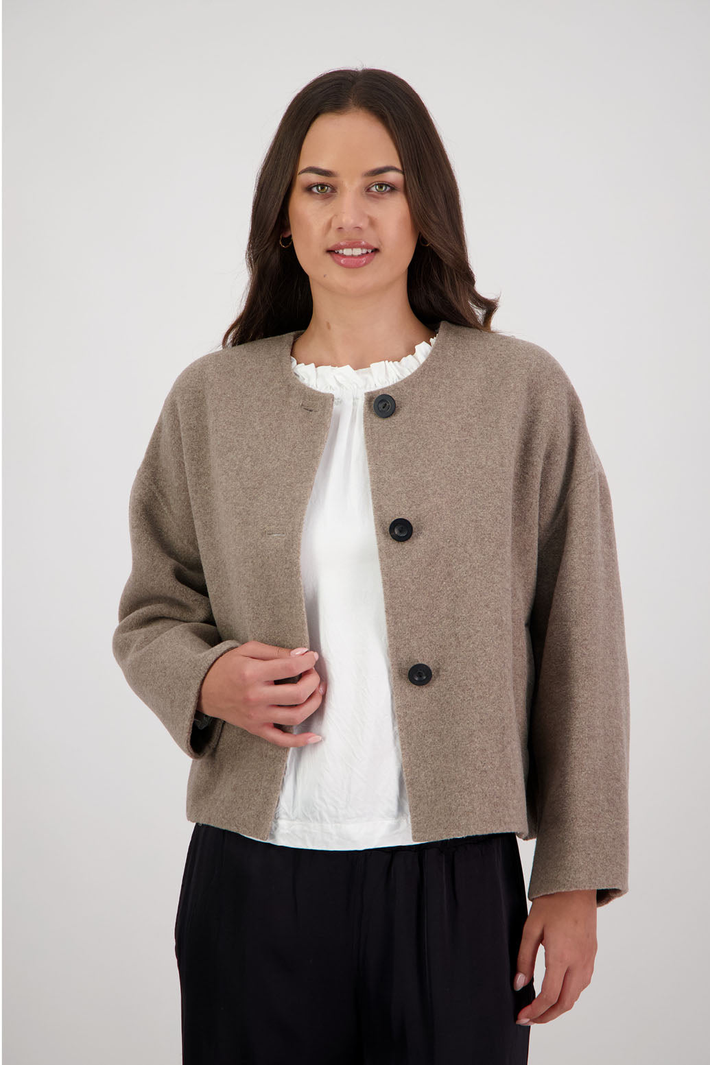 Renee Jacket in Taupe by Briarwood NZ. Features, no collar, button closure, shaped sleeves, pockets, drop shoulder and dart type pleats on the hem of the jacket