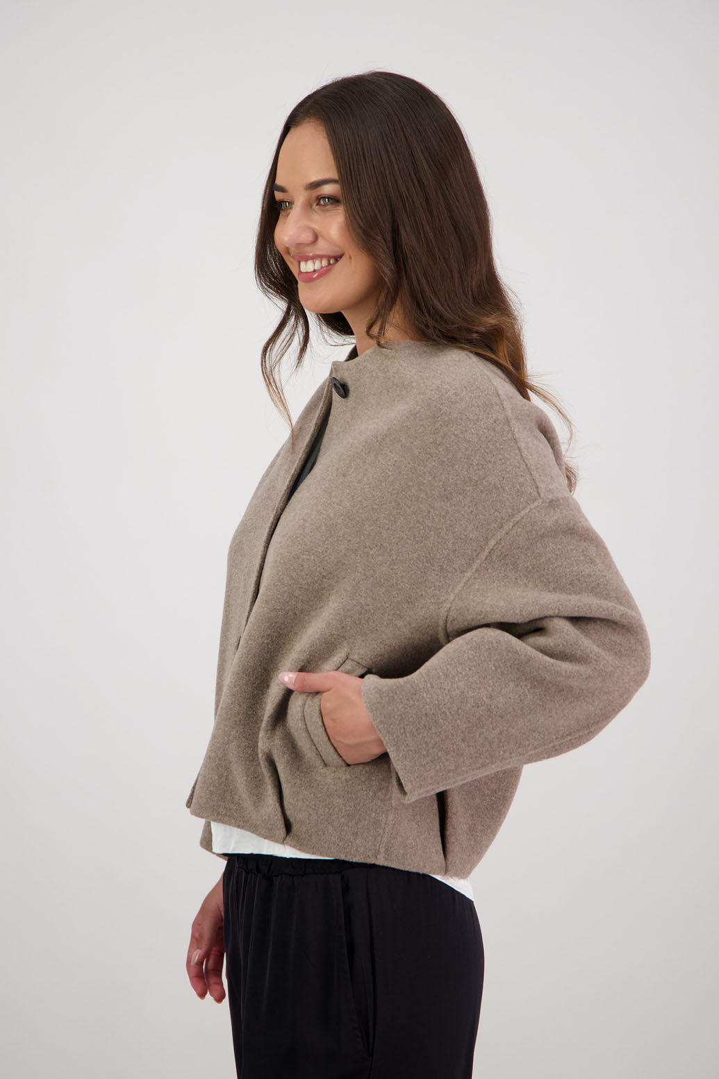 Renee Jacket in Taupe by Briarwood NZ. Features, no collar, button closure, shaped sleeves, pockets, drop shoulder and dart type pleats on the hem of the jacket