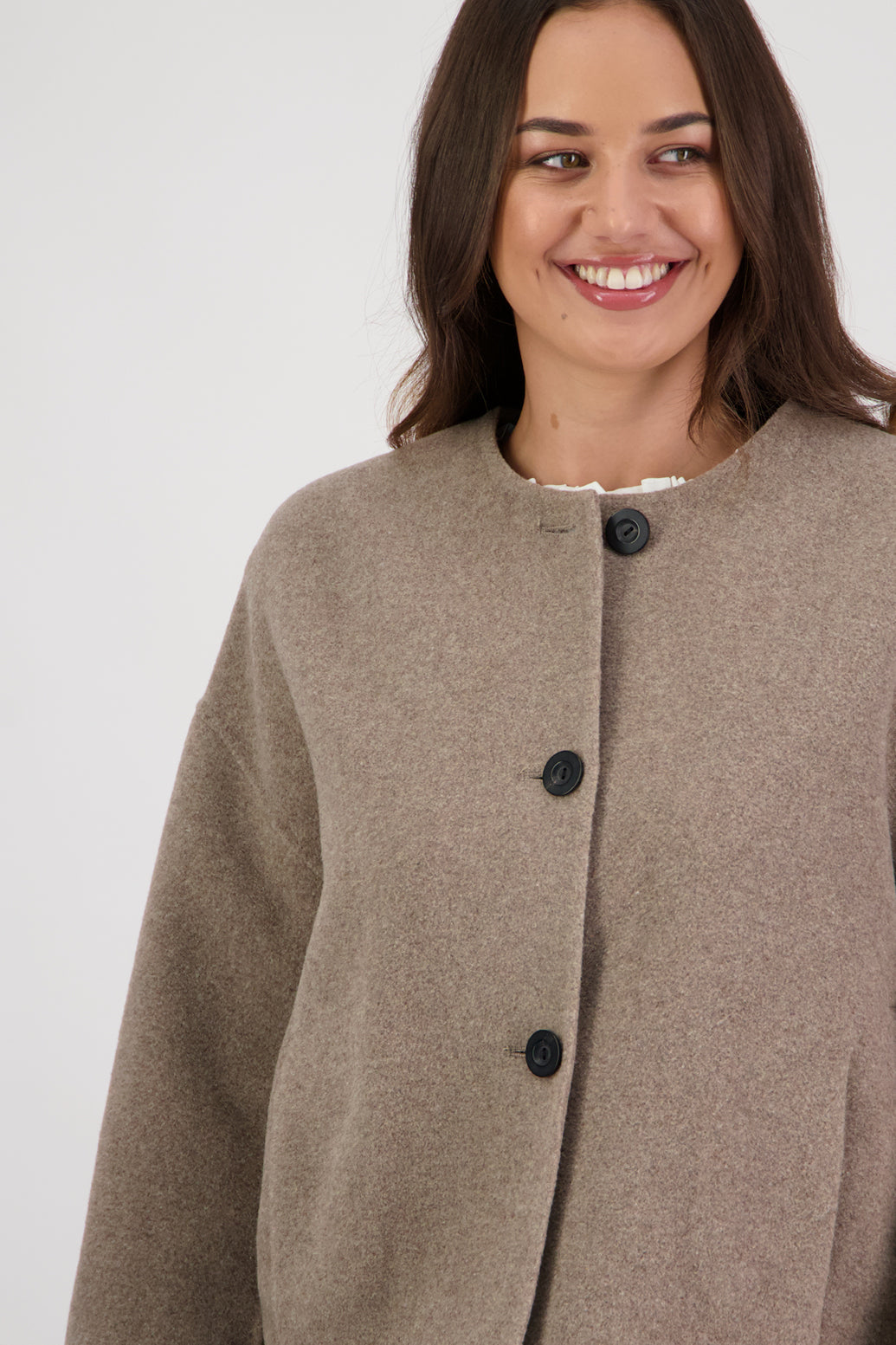 Renee Jacket in Taupe by Briarwood NZ. Features, no collar, button closure, shaped sleeves, pockets, drop shoulder and dart type pleats on the hem of the jacket
