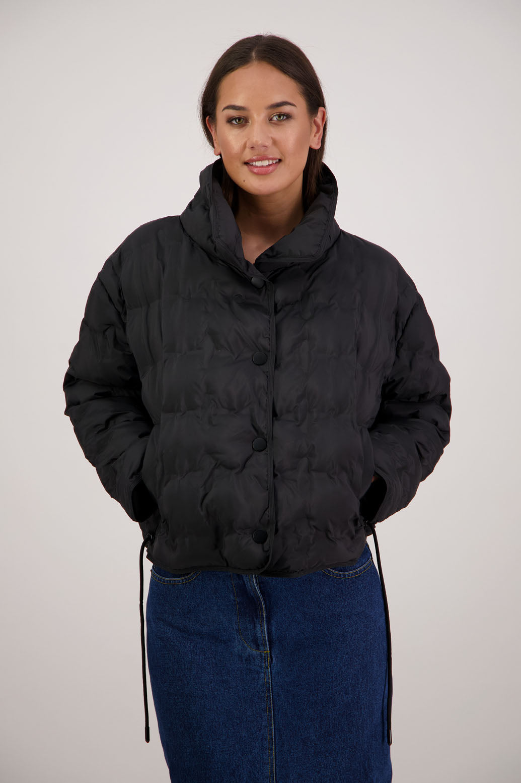 Rhodes Padded Jacket in Black by Briarwood NZ. Features, magnetic dome closures, filled with plush fibres, elastic pull across the back with toggles to hold it in place, high collar with invisible magnetic closure, pockets