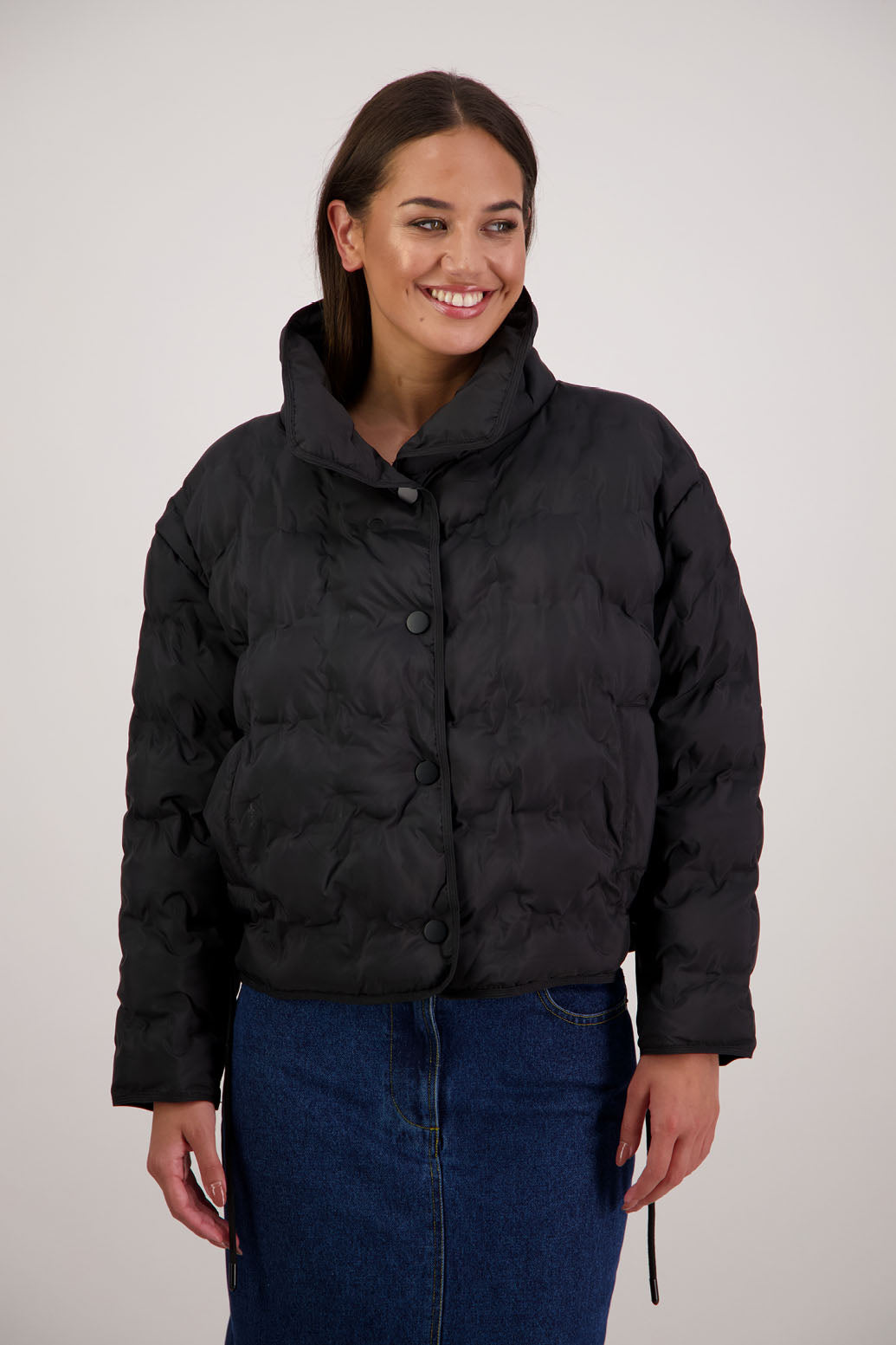 Rhodes Padded Jacket in Black by Briarwood NZ. Features, magnetic dome closures, filled with plush fibres, elastic pull across the back with toggles to hold it in place, high collar with invisible magnetic closure, pockets