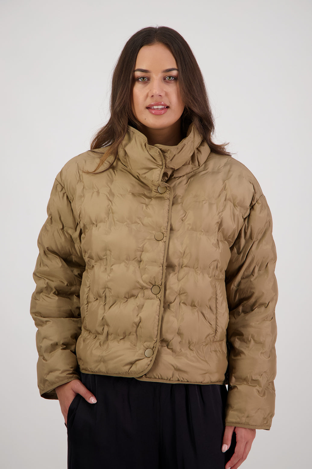 Rhodes Padded Jacket in Tan by Briarwood NZ. Features, magnetic dome closures, filled with plush fibres, elastic pull across the back with toggles to hold it in place, high collar with invisible magnetic closure, pockets