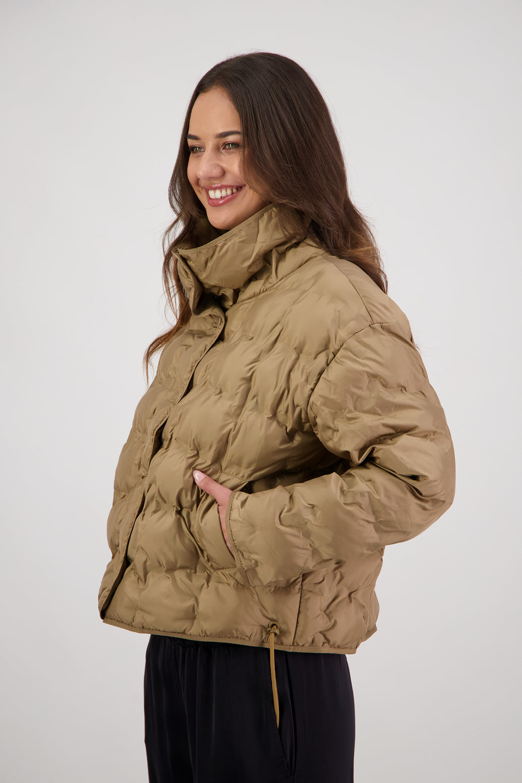 Rhodes Padded Jacket in Tan by Briarwood NZ. Features, magnetic dome closures, filled with plush fibres, elastic pull across the back with toggles to hold it in place, high collar with invisible magnetic closure, pockets