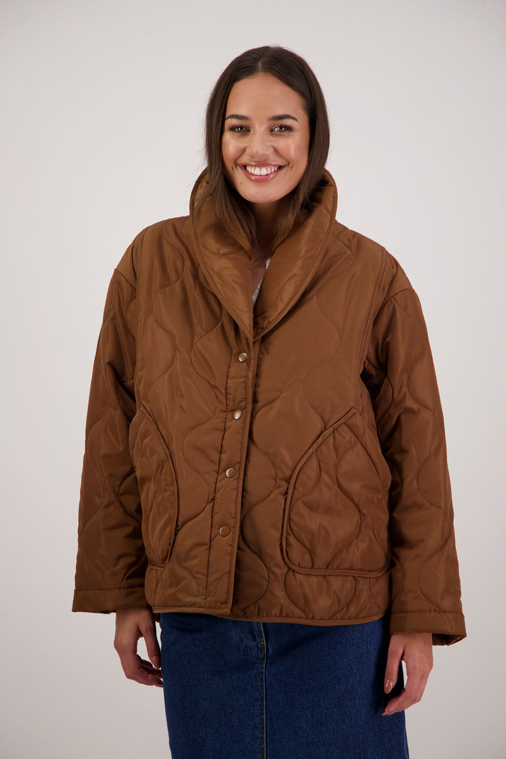 BESTSELLER. Chapman Quilted Jacket in Tan by Briarwood NZ. Quilted swirl design, high collar, side split detail, buttons front, stitched on pockets, slightly longer in the back, box fit, lined