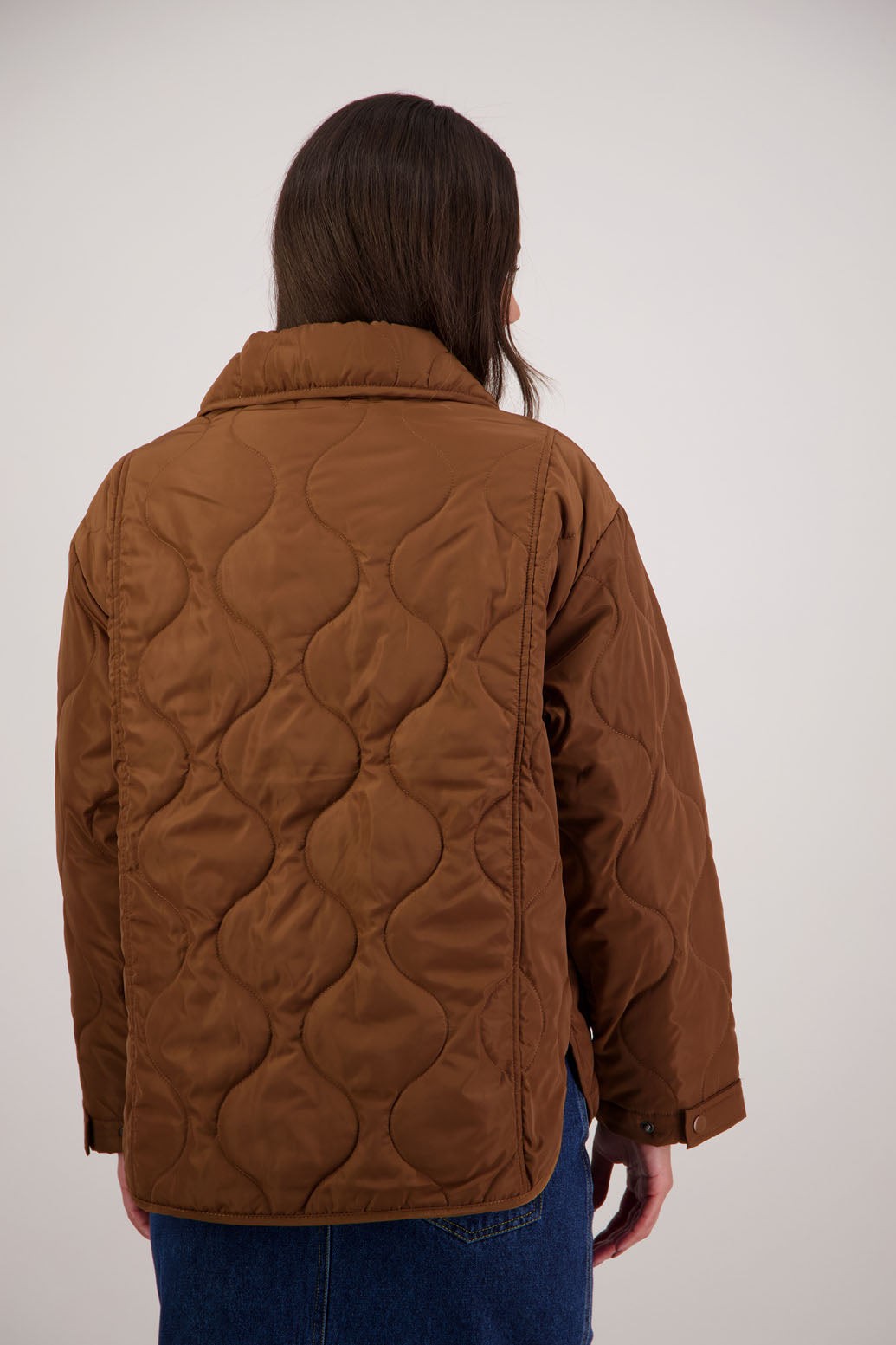 BESTSELLER. Chapman Quilted Jacket in Tan by Briarwood NZ. Quilted swirl design, high collar, side split detail, buttons front, stitched on pockets, slightly longer in the back, box fit, lined