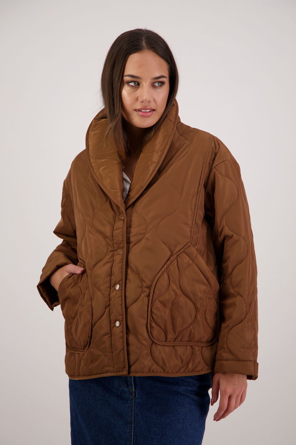 BESTSELLER. Chapman Quilted Jacket in Tan by Briarwood NZ. Quilted swirl design, high collar, side split detail, buttons front, stitched on pockets, slightly longer in the back, box fit, lined