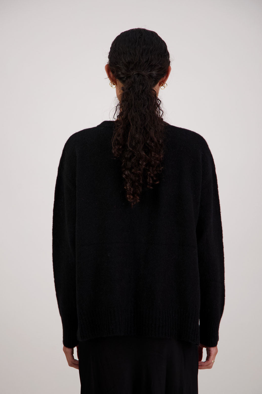 Fable Cardigan in Black by Briarwood NZ. Alpaca/Wool blend long sleeve cardigan with side splits and longer at the back