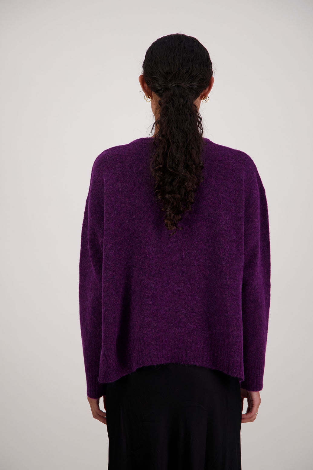 Fable Cardigan in Purple by Briarwood NZ. Alpaca/Wool blend long sleeve cardigan with side splits and longer at the back