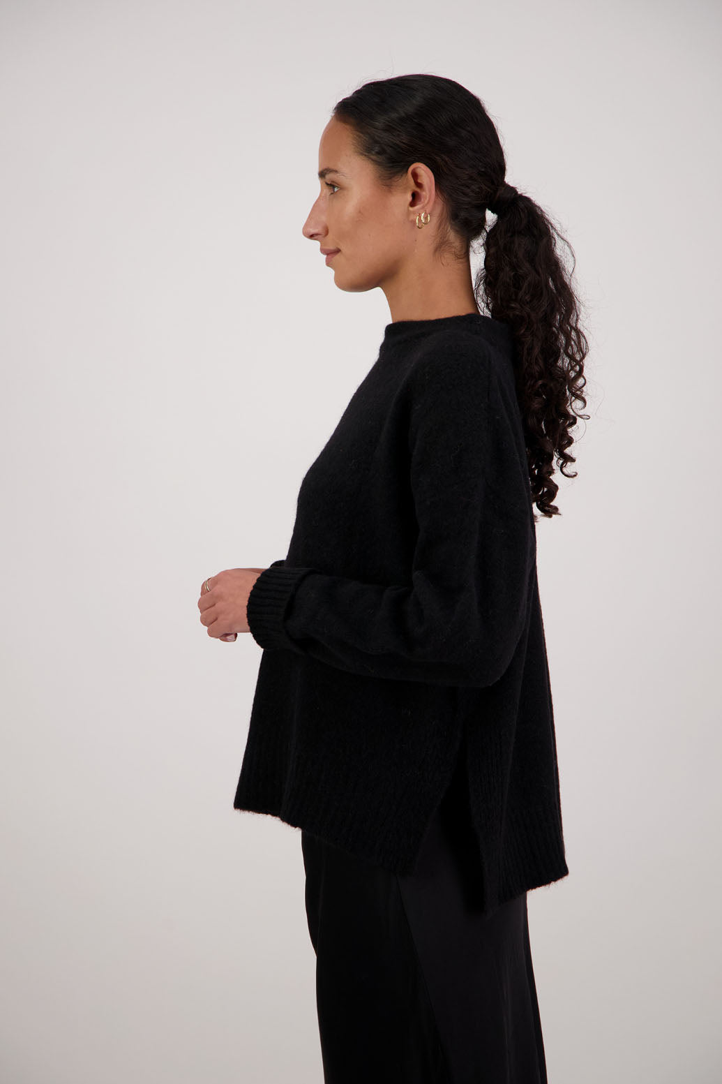 Feather Jumper in Black by Briarwood NZ. Alpaca/Wool blend long sleeve, funnel neck jumper with side splits and longer at the back