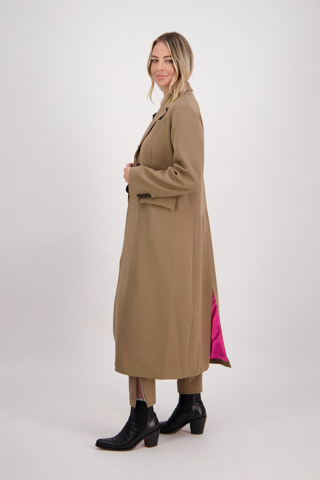 Camel tailored long coat with fuchsia lining. Lapel pockets and high back split. Hannah