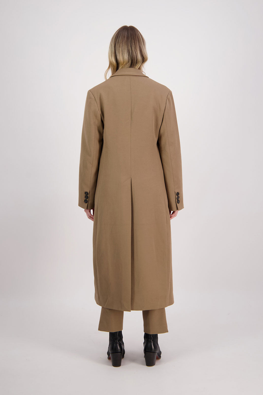 Camel tailored long coat with fuchsia lining. Lapel pockets and high back split. Hannah