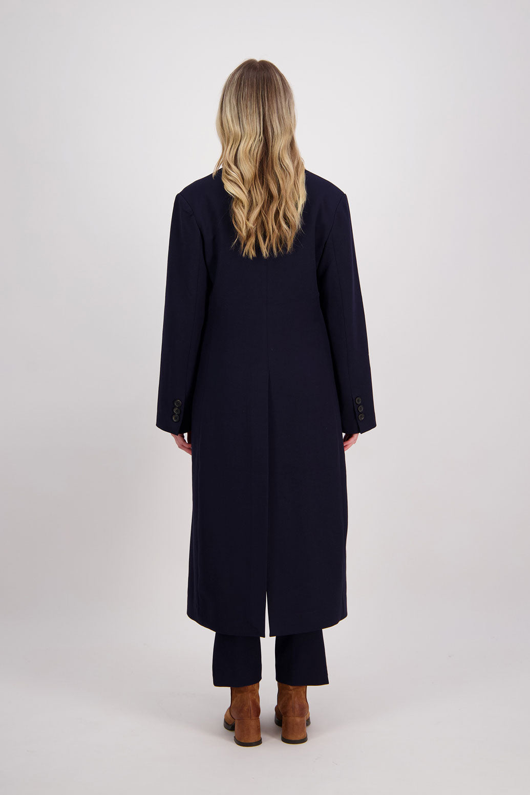 Ink/Dark Blue tailored long coat with fuchsia lining. Lapel pockets and high back split. Hannah