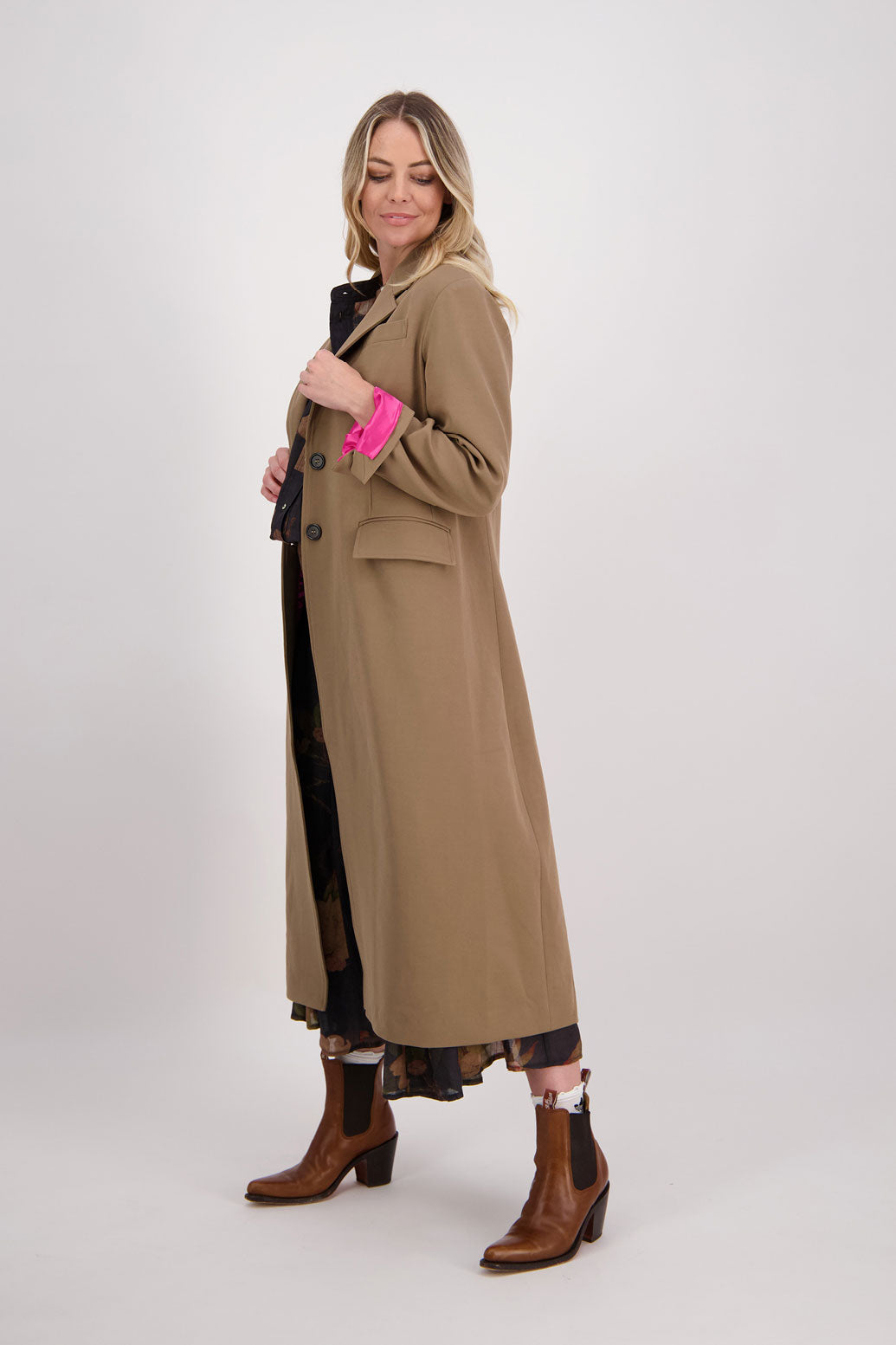 Camel tailored long coat with fuchsia lining. Lapel pockets and high back split. Hannah