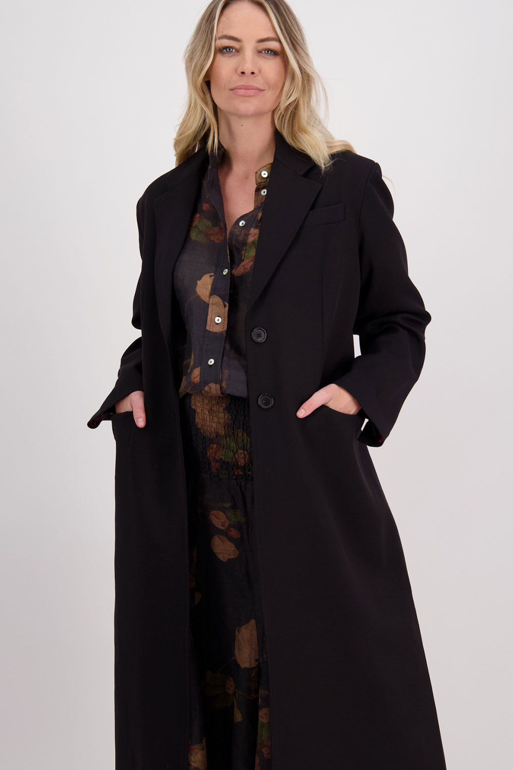 Black tailored long coat with fuchsia lining. Lapel pockets and high back split. Hannah