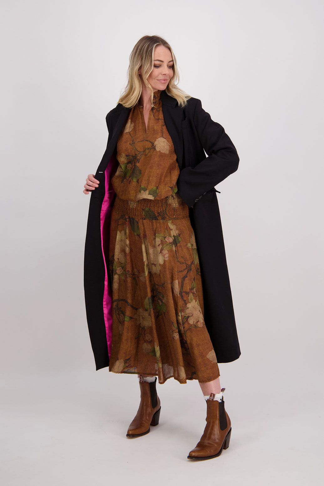 Black tailored long coat with fuchsia lining. Lapel pockets and high back split. Hannah