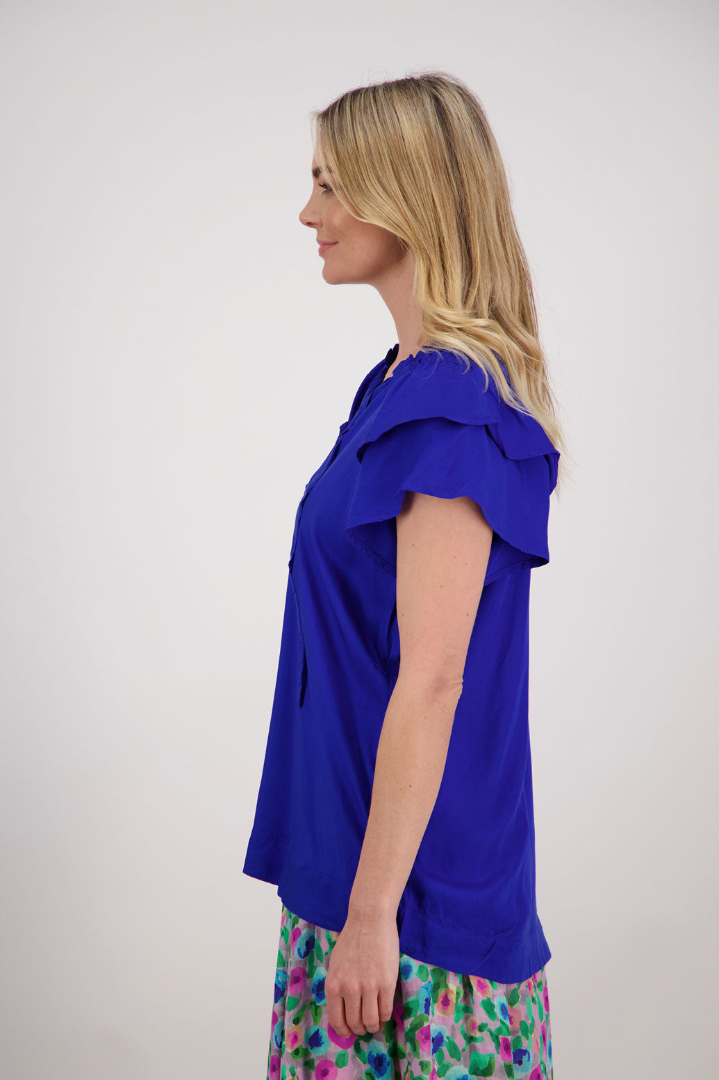 Pansy Womens Short Sleeve top with V Neck and Tie. Double ruffle over the shoulder and shaped hem. Bright Blue