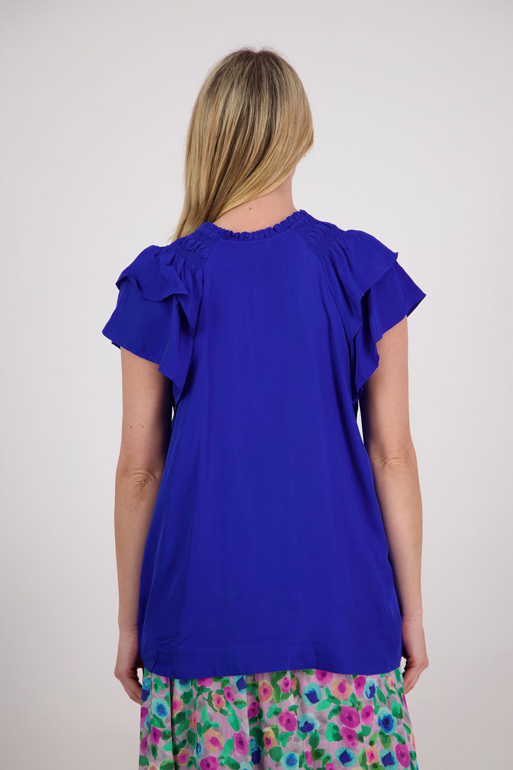 Pansy Womens Short Sleeve top with V Neck and Tie. Double ruffle over the shoulder and shaped hem. Bright Blue