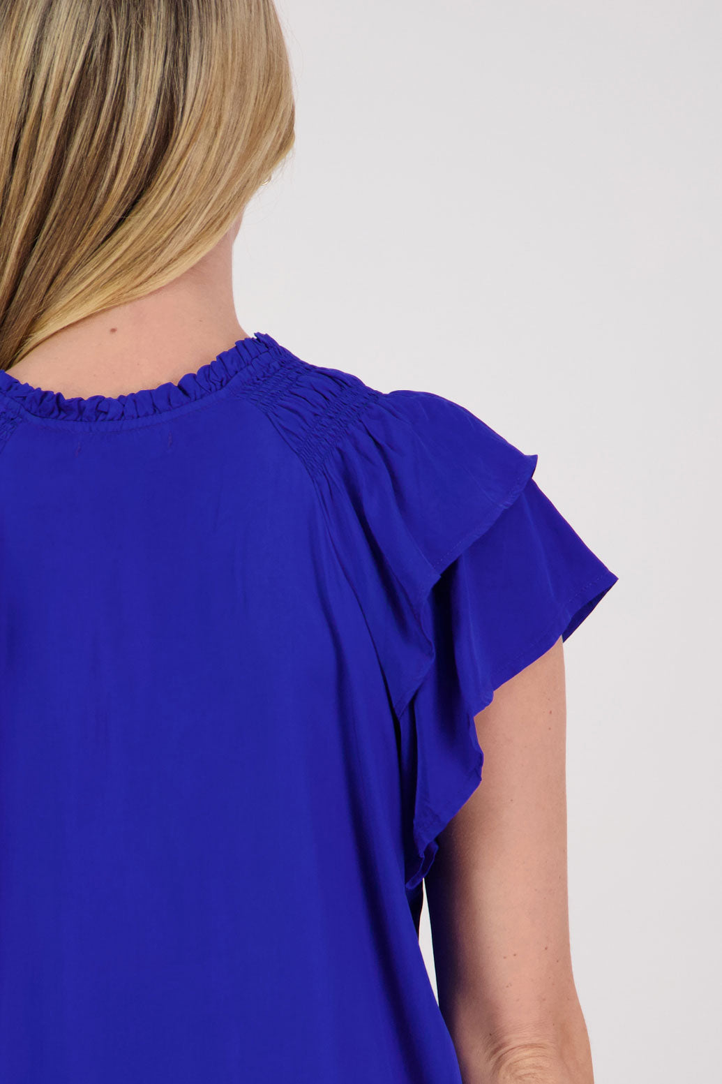 Pansy Womens Short Sleeve top with V Neck and Tie. Double ruffle over the shoulder and shaped hem. Bright Blue