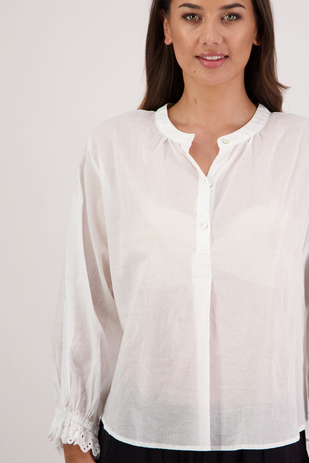 Briarwood NZ. Woman wearing a Randall white shirt with long sleeves against a plain background. Subtle embroidered sleeves.