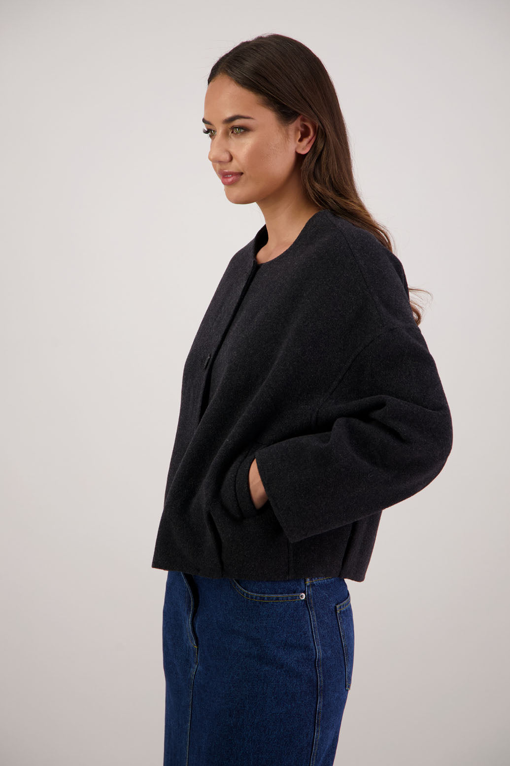 Renee Jacket in Black by Briarwood NZ. Features, no collar, button closure, shaped sleeves, pockets, drop shoulder and dart type pleats on the hem of the jacket