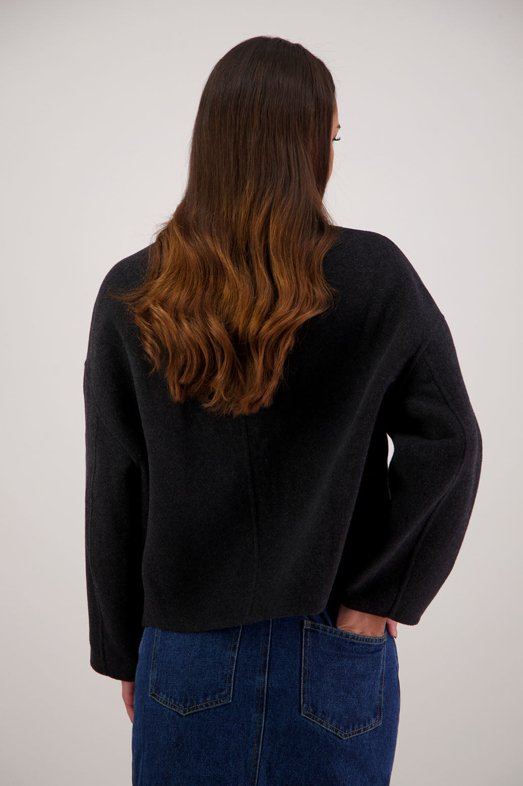Renee Jacket in Black by Briarwood NZ. Features, no collar, button closure, shaped sleeves, pockets, drop shoulder and dart type pleats on the hem of the jacket