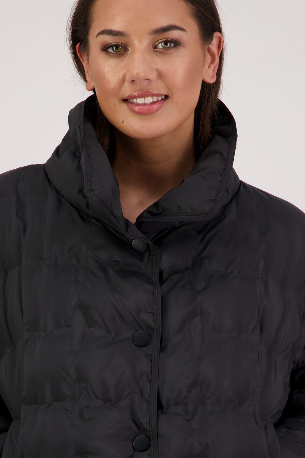 Rhodes Padded Jacket in Black by Briarwood NZ. Features, magnetic dome closures, filled with plush fibres, elastic pull across the back with toggles to hold it in place, high collar with invisible magnetic closure, pockets