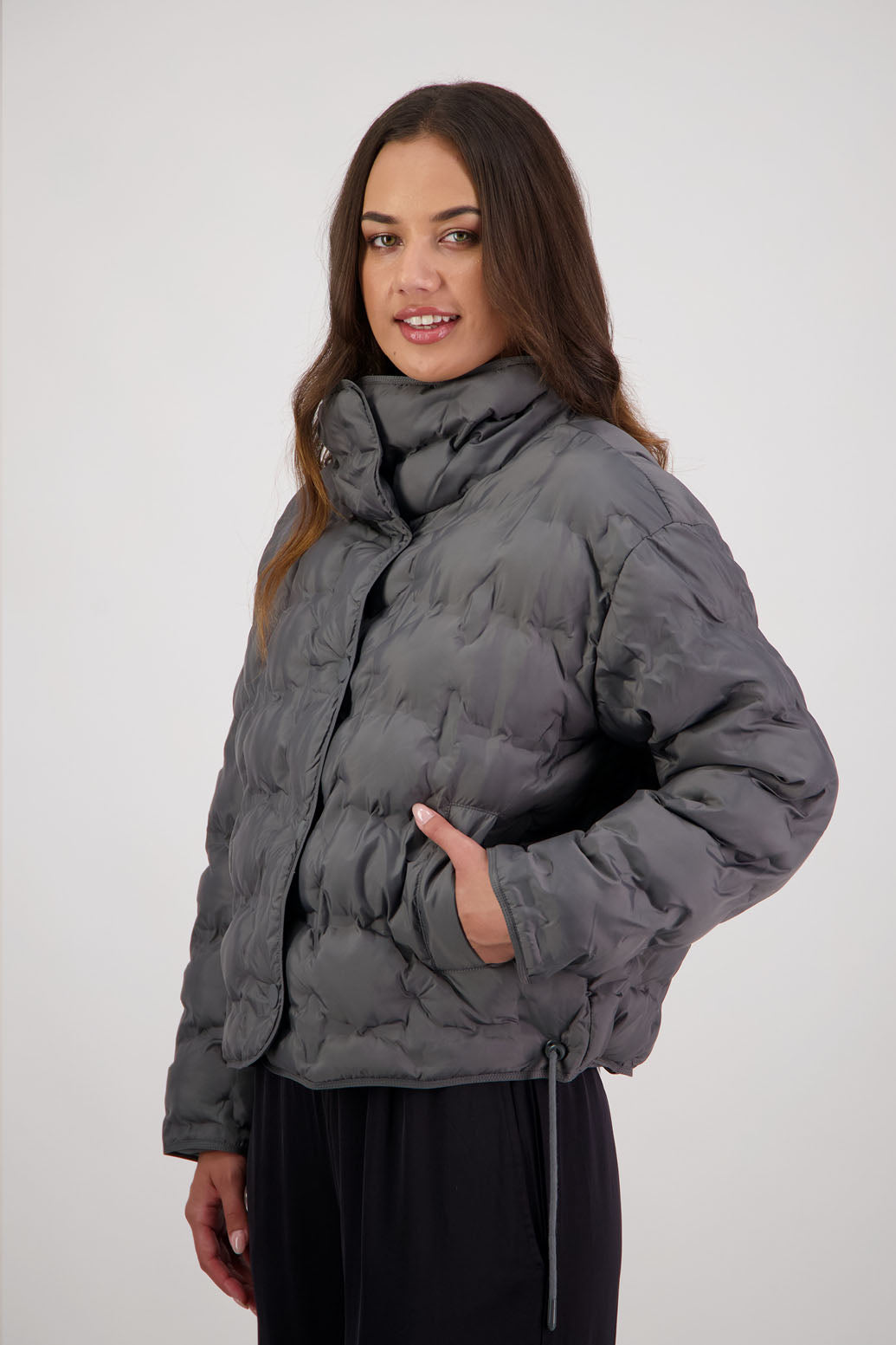 Rhodes Padded Jacket in Charcoal by Briarwood NZ. Features, magnetic dome closures, filled with plush fibres, elastic pull across the back with toggles to hold it in place, high collar with invisible magnetic closure, pockets