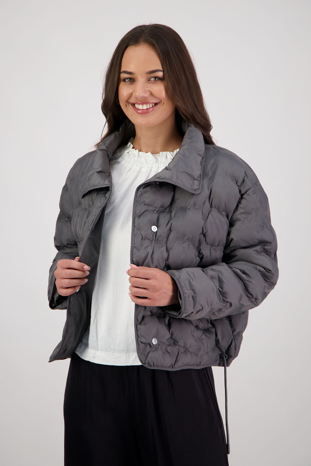 Rhodes Padded Jacket in Charcoal by Briarwood NZ. Features, magnetic dome closures, filled with plush fibres, elastic pull across the back with toggles to hold it in place, high collar with invisible magnetic closure, pockets