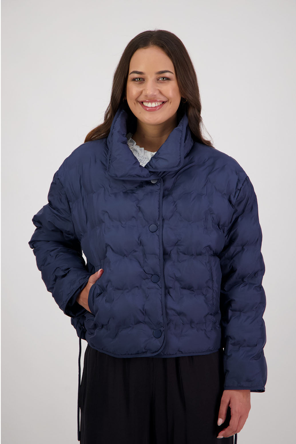 Rhodes Padded Jacket in Ink by Briarwood NZ. Features, magnetic dome closures, filled with plush fibres, elastic pull across the back with toggles to hold it in place, high collar with invisible magnetic closure, pockets