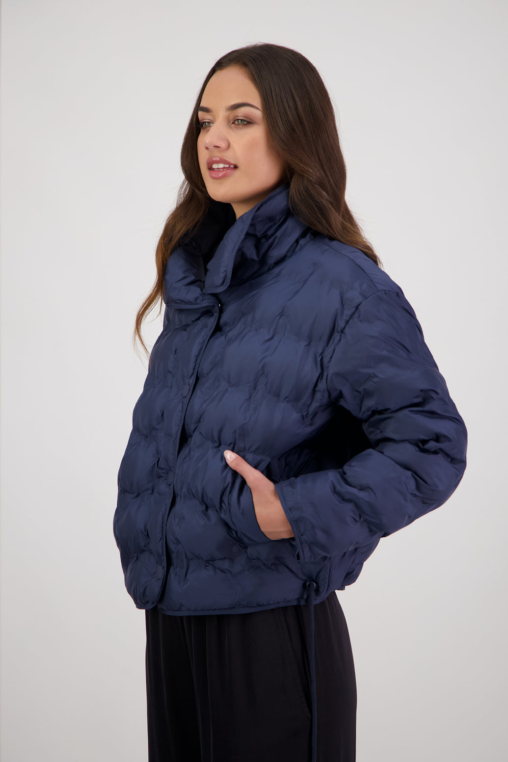 Rhodes Padded Jacket in Ink by Briarwood NZ. Features, magnetic dome closures, filled with plush fibres, elastic pull across the back with toggles to hold it in place, high collar with invisible magnetic closure, pockets