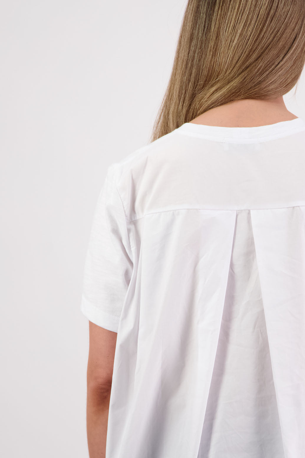 Womens oversized black cotton t-shirt with scooped neckline and swing back with cotton poplin pleat. Briarwood NZ. Smiley, White