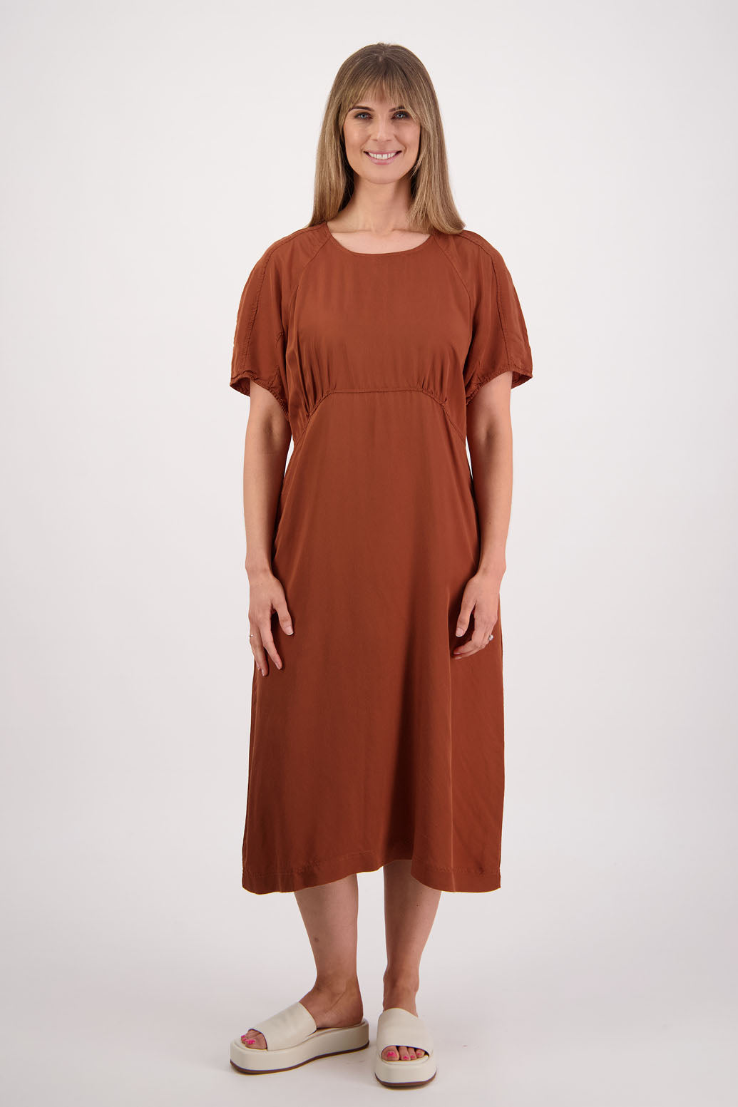 Womens tan dress with curved empire line bodice. Slim fitting body and midi length. Viscose. Briarwood NZ. Stacey