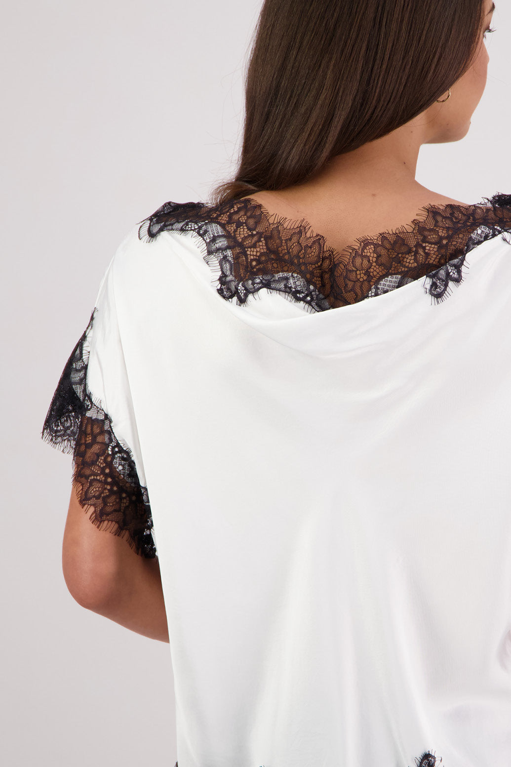 Closeup back view Briarwood Tabby Top in a ivory, 100% viscose with black lace trims.